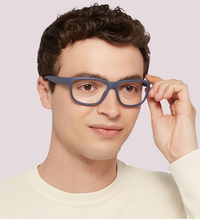A young man with short brown curls wearing Harrington Sport Pulse glasses in dark blue