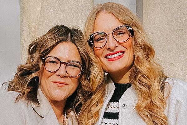 Two smiling women wearing glasses