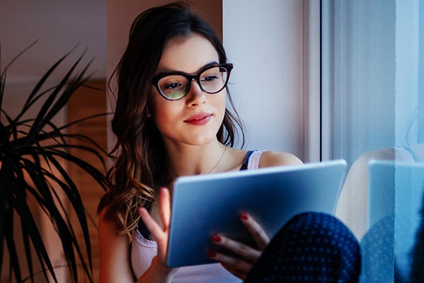 Woman wearing glasses looking at a tablet