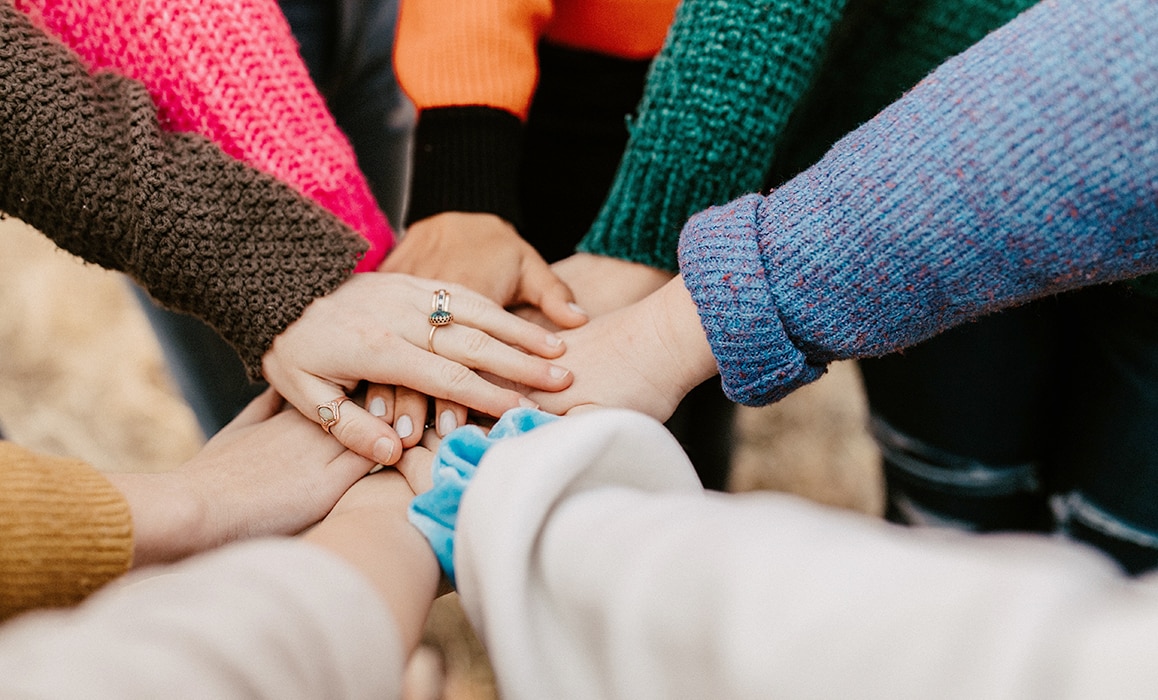 Hands placed on top of each other as a sign of unity