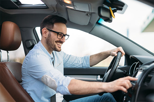 Smiling man with glasses inside a car