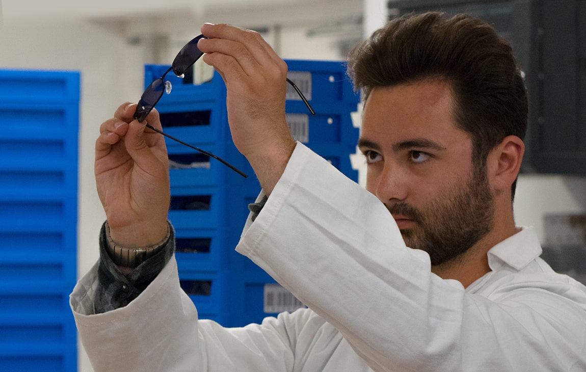 A lab technician inspects a pair of sunglasses