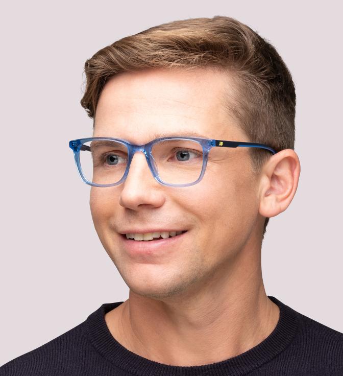A smiling man with short brown hair wearing crystal blue New Balance glasses