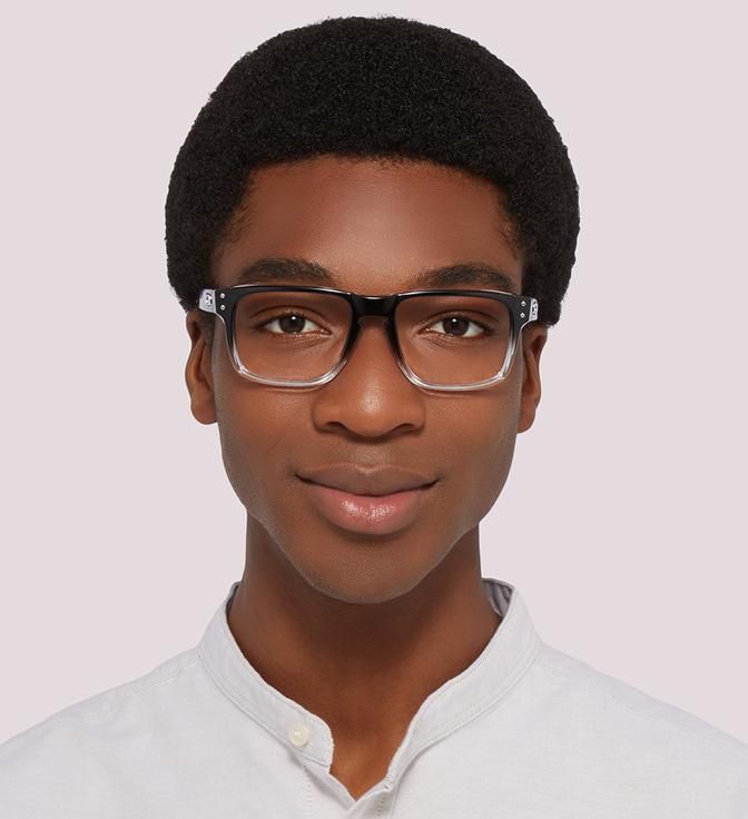 A young black man with a short afro wearing Oakley Holbrook glasses in polished black clear fade