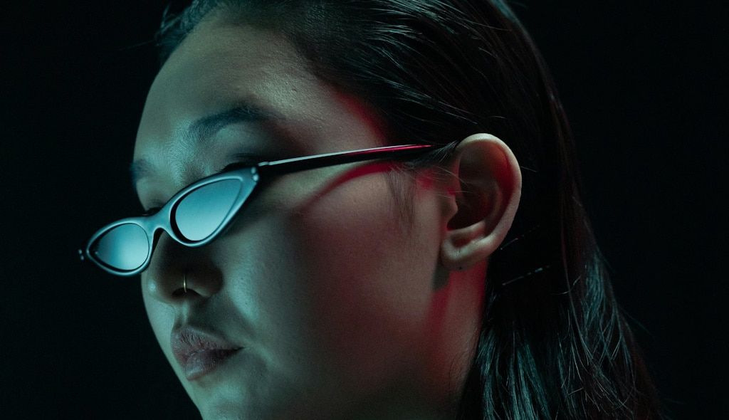 Close-up of an Asian woman wearing very small cat-eye sunglasses