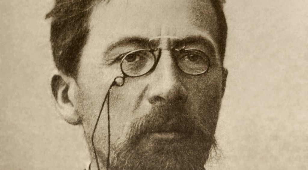 A black-and-white photo of Russian writer Anton Chekhov wearing pince-nez glasses.