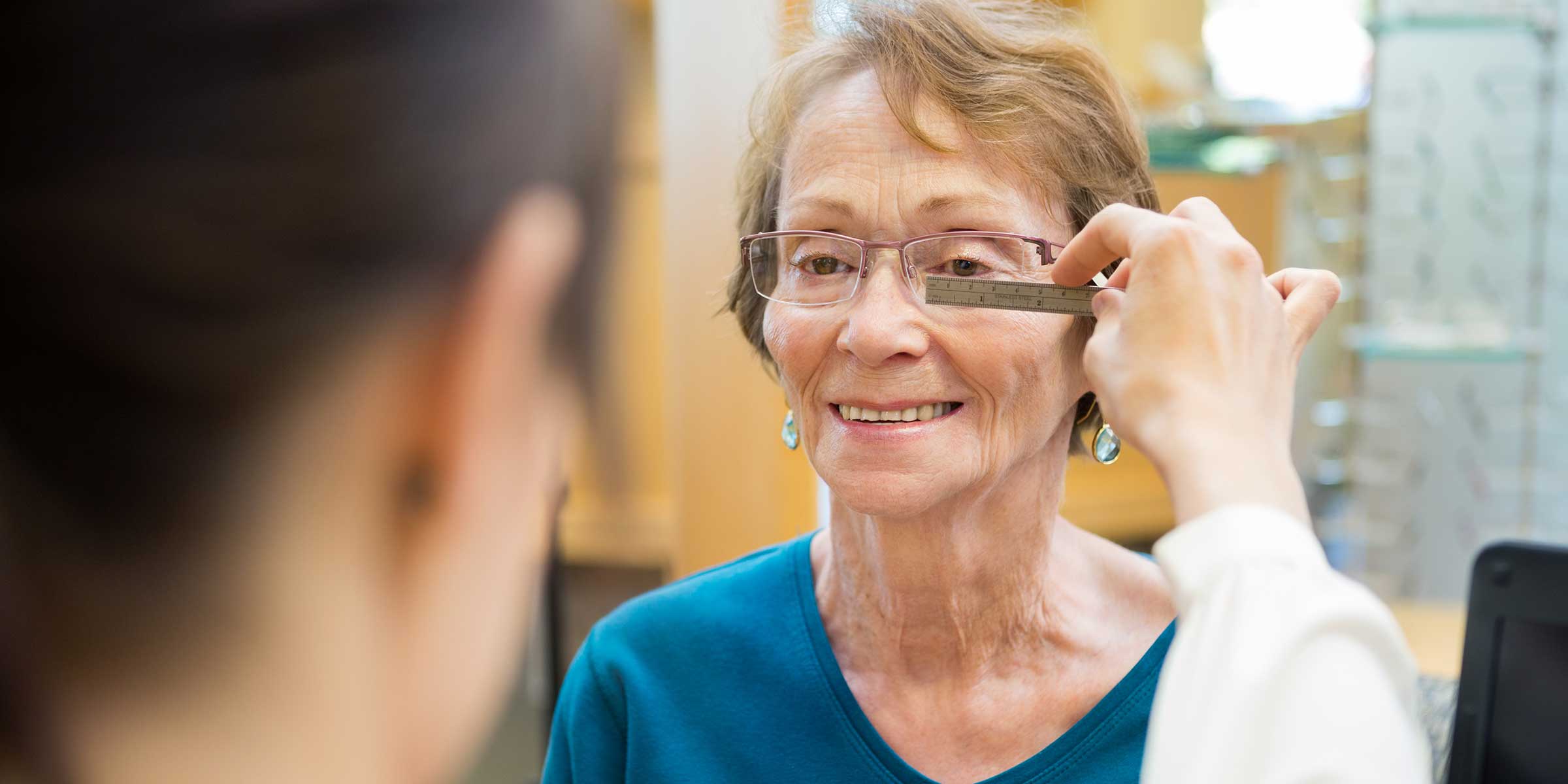 An optician measuring a woman's PD