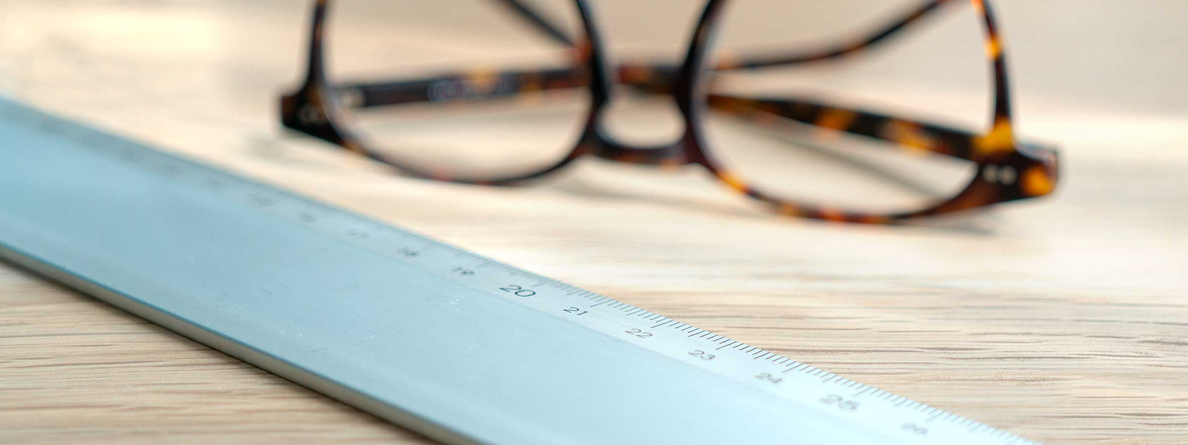 A pair of glasses next to a ruler