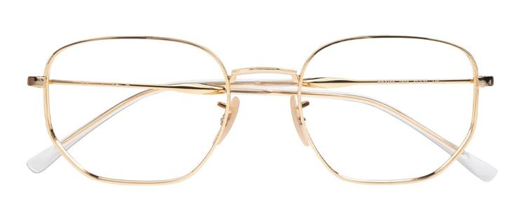 Round gold metal Ray-Ban glasses with geometric lines, clear rubber nose pads and white plastic tips, folded.