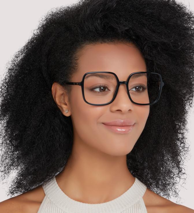 A woman with bushy black curls wearing Scout Calina glasses