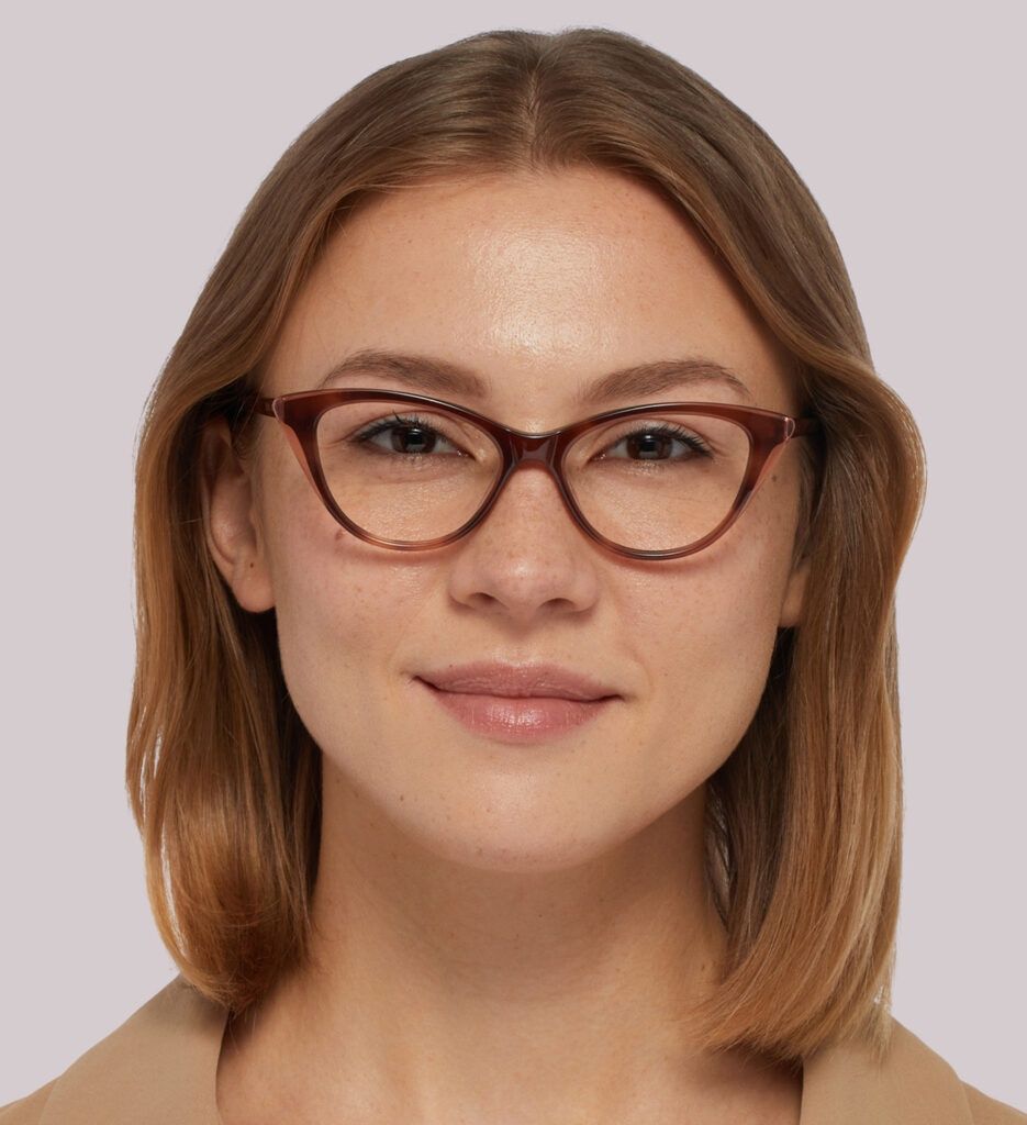 A lady with light brown, medium-length hair wearing a subtle cat-eye made of dark-red acetate.